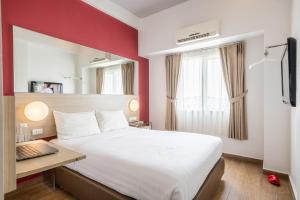 a hotel room with a large bed and a desk at Monoloog Hotel Bekasi in Bekasi