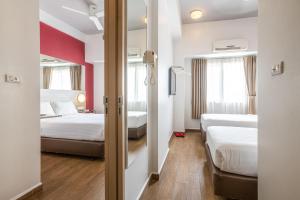 a hotel room with two beds and a window at Monoloog Hotel Bekasi in Bekasi