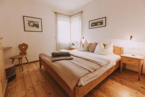 1 dormitorio con 1 cama grande y suelo de madera en Weinberghof, en Appiano sulla Strada del Vino