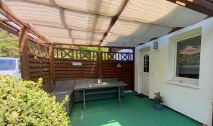 un patio al aire libre con mesa y techo de madera en Ferienwohnung Beck, en Trassenheide