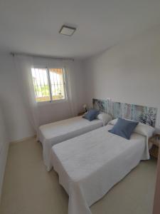 2 Betten in einem weißen Zimmer mit Fenster in der Unterkunft EDA Paradise Vera Playa in Vera