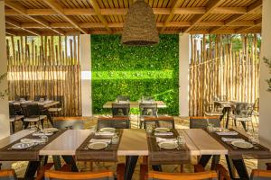 un restaurante con mesas y sillas y una pared verde en Olympion Asty Hotel, en Olimpia