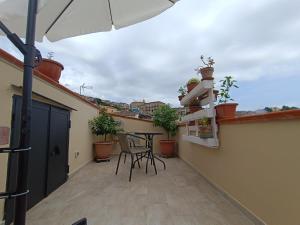 a balcony with a table and chairs and an umbrella at B & B Domus San PietRo in Rossano