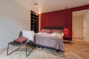 um quarto com uma cama e uma cadeira em BEE n BEE em Bruges