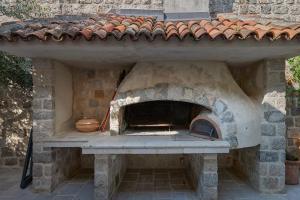 a stone pizza oven in a brick building at Villa Perastian Thriton in Perast