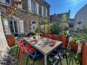 einen Holztisch und Stühle auf einer Terrasse in der Unterkunft Villa Belz, 3 pièces, 2 personnes - FR-1-479-142 in Belz