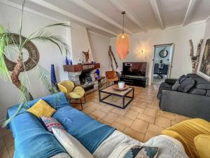 ein Wohnzimmer mit einem blauen Sofa und einem TV in der Unterkunft Villa Belz, 3 pièces, 2 personnes - FR-1-479-142 in Belz