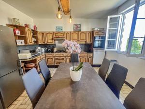 eine Küche mit einem Tisch mit Stühlen und einem Kühlschrank in der Unterkunft Villa Belz, 3 pièces, 2 personnes - FR-1-479-142 in Belz
