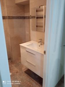 Un baño con lavabo blanco y ducha. en Piso Attila, en Sanxenxo
