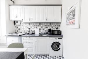 a kitchen with white cabinets and a washing machine at Chic Flat 5 min to Galata Tower in Istiklal Ave in Istanbul