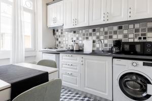 a kitchen with white cabinets and a washer at Chic Flat 5 min to Galata Tower in Istiklal Ave in Istanbul