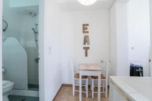 a bathroom with a toilet and a table and chairs at Livadia Seaside Studios 11 in Parikia