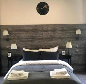 1 dormitorio con 1 cama grande y reloj en la pared en Room's by Sleephotels, en Hamburgo