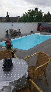 a table and chairs next to a swimming pool at B&B Carpe Diem in Eijsden