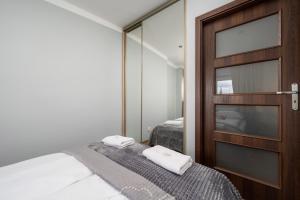 a small bedroom with a bed and a mirror at Market Square Corner Apartment Kuźnicza by Renters in Wrocław
