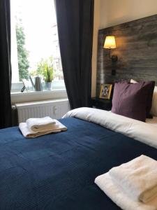 a bedroom with a blue bed with towels on it at Room's by Sleephotels in Hamburg
