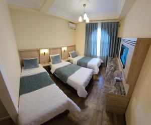 ギャンジャにあるOld City Ganjaのベッド2台とテレビが備わるホテルルームです。