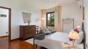 a bedroom with a bed and a dresser and a window at VILLA IRENE 6, Emma Villas in Montecarlo