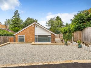 a home with a gravel driveway in front of a house at Pass the Keys Modern Spacious 3BR Bungalow Parking Oxford in Oxford