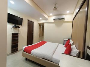 1 dormitorio con 1 cama y TV de pantalla plana en Payal Hotel Panvel en Navi Mumbai