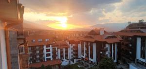 a view of a city with the sunset in the background at Penthouse Harriet Bansko in Bansko