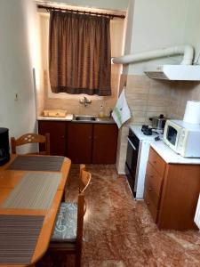 een kleine keuken met een tafel en een magnetron bij Ηλιαχτίδα Iliachtida apartment in Chios