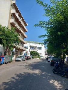 een straat met auto's geparkeerd voor een gebouw bij Ηλιαχτίδα Iliachtida apartment in Chios