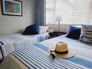 a hat sitting on top of two beds in a room at Mangrove Beach Estate - 3 Mtwalume in Port Shepstone