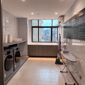 a laundry room with a window and a chair in it at City Hotel Xiamen-Free Welcome Fruits in Xiamen