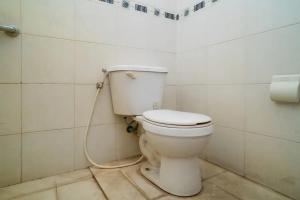a bathroom with a toilet with a hose at Puri Saras Bintaro Syariah Mitra RedDoorz in Jurangmanggu +24 photos