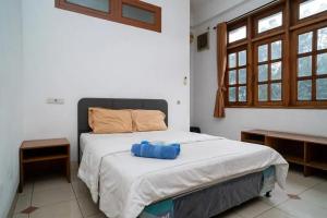 een slaapkamer met een bed met een blauwe doos erop bij Puri Saras Bintaro Syariah Mitra RedDoorz in Jurangmanggu