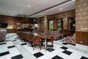una sala da pranzo con tavolo e sedie di Puri Saras Bintaro Syariah Mitra RedDoorz a Jurangmanggu