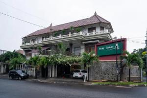 un gran edificio con un letrero que lee el choque de hierba en Puri Saras Bintaro Syariah Mitra RedDoorz en Jurangmanggu