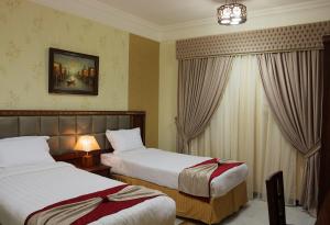 a hotel room with two beds and two lamps at Safari Hotel Apartment (Formerly Ewa Safari) in Jeddah