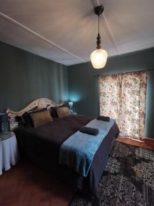 a bedroom with a large bed and a window at Greyton Toad Hall Guesthouse - no load shedding in Greyton