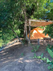 a tent under a tree with a wooden bench at สามชุกบ้านสวน in Sam Chuk