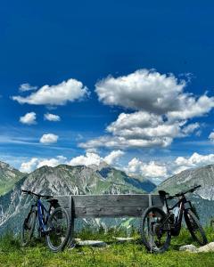 two bikes parked next to a bench in the mountains at Haus St. Martin in Klösterle am Arlberg