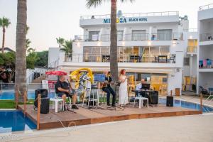 a group of people playing music in front of a hotel at Mimoza Beach Hotel in Yenibosazici