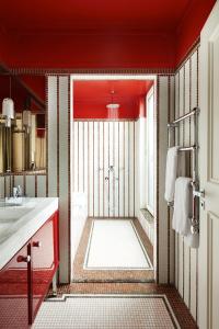 a red bathroom with a shower and a sink at Villa-des-Prés in Paris