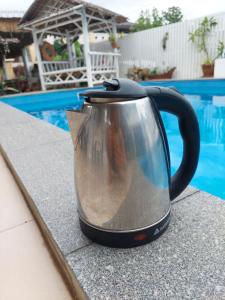 a tea kettle sitting on a counter next to a pool at Baan sikhao Yanui in Rawai Beach