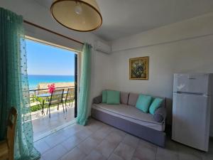 a living room with a couch and a view of the ocean at Corfu Glyfada Menigos Resort 149 in Glyfada