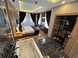 ein Badezimmer mit einer Badewanne und ein Schlafzimmer mit einem Bett in der Unterkunft Kaya Life Resort in Uzungöl
