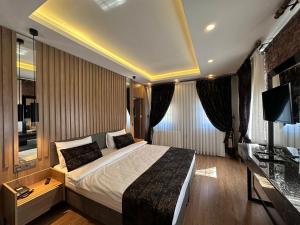 ein Hotelzimmer mit einem Bett und einem Fernseher in der Unterkunft Kaya Life Resort in Uzungöl
