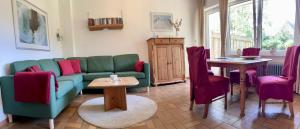 sala de estar con sofá, mesa y sillas en Appartementhaus Meridian, en Sankt Peter-Ording