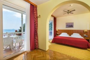 sypialnia z łóżkiem i balkonem w obiekcie Hotel Zora w Primošten