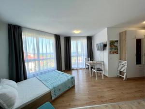 Un dormitorio con una cama, un escritorio y ventanas. en Студио Галерия - Studio Galeria, en Byala 45 fotos más