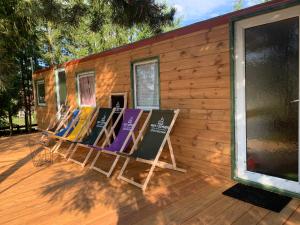 a row of deck chairs sitting on a porch at Domek "Igły i Szyszki" 