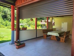 a screened in porch with a table and benches at Apartma Kolpa in Gradac