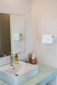 a bathroom with a white sink and a mirror at Atami-view Resort in Atami