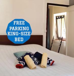 uma cama branca com um sinal de estacionamento gratuito, uma cama king-size king-size; em Appartement 2 Pièces à 5 Minutes des Musées em Grasse